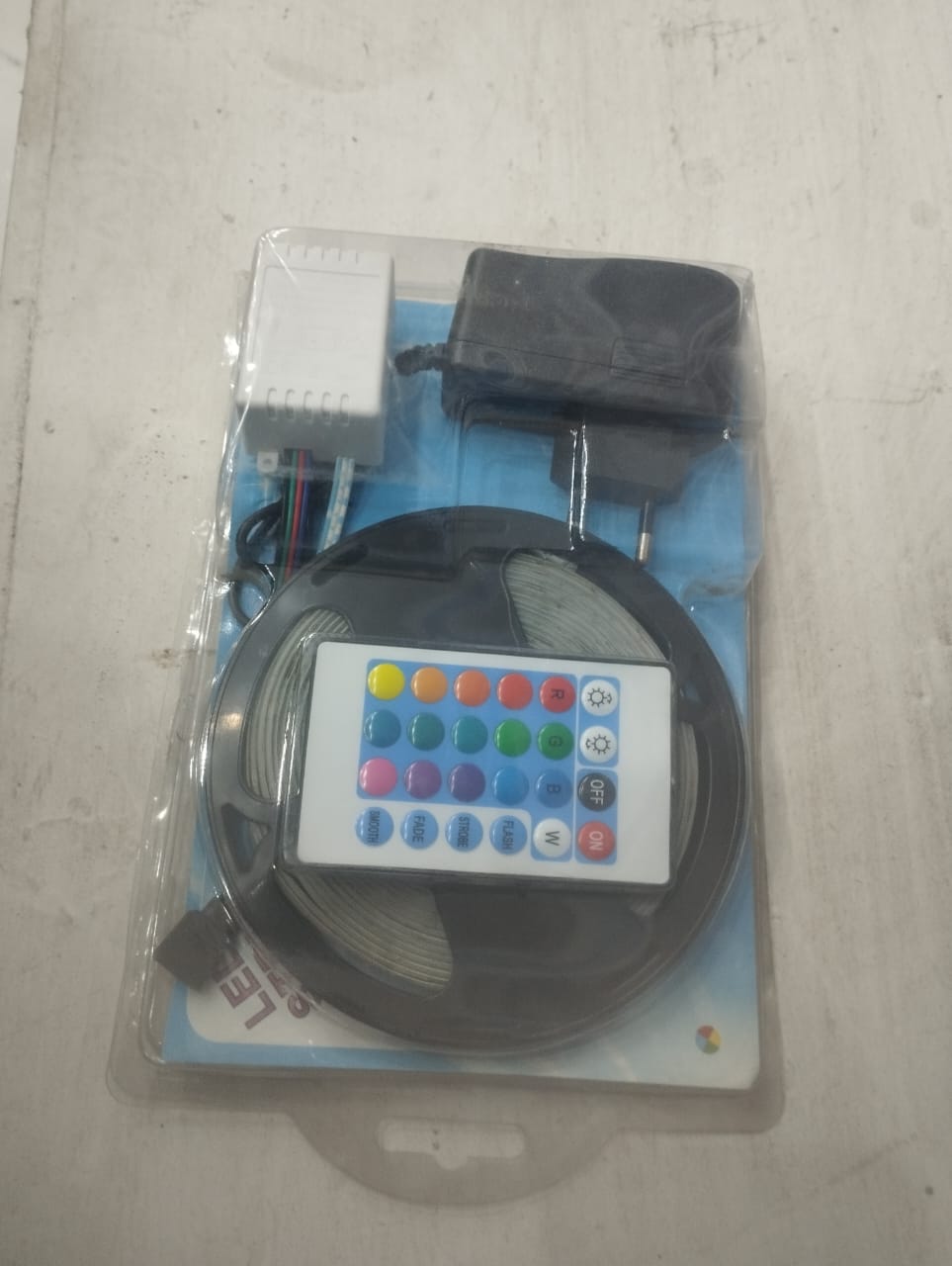 Packaged LED strip kit with remote control on a light gray surface
