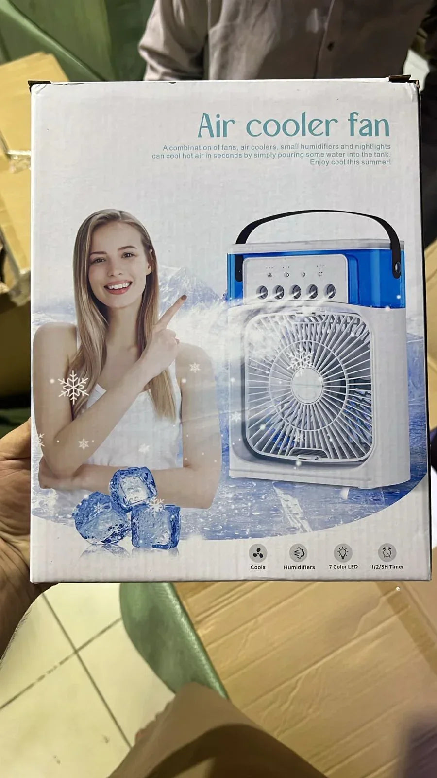 Box of an air cooler fan with a woman and fan illustration on the packaging.
