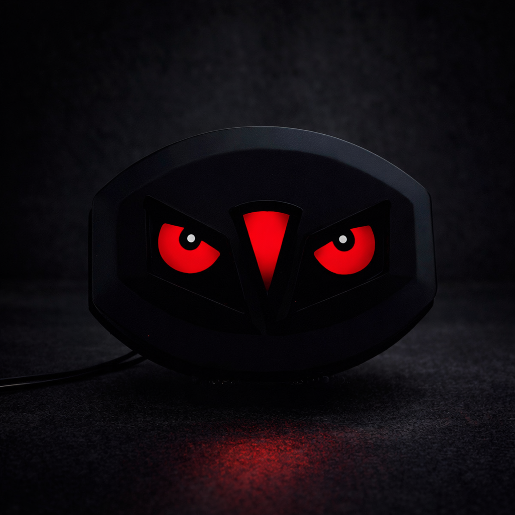 Black gaming mouse with red glowing eyes on a dark background